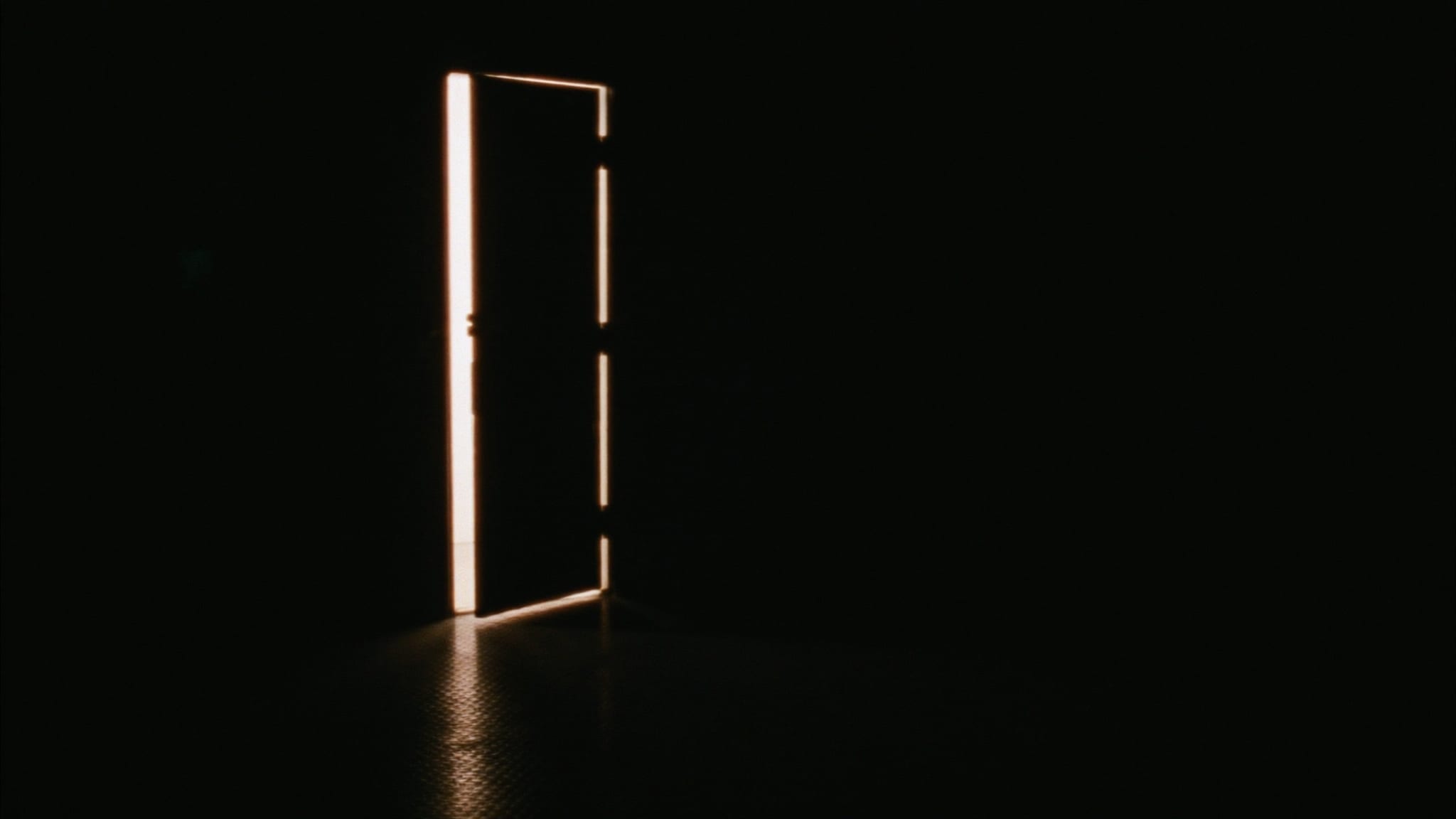 Una porta socchiusa da cui entra una lama di luce calda.