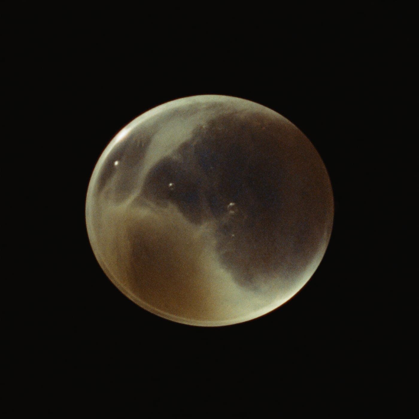 Una sfera d'acqua sospesa, la superficie increspata dalla luce.