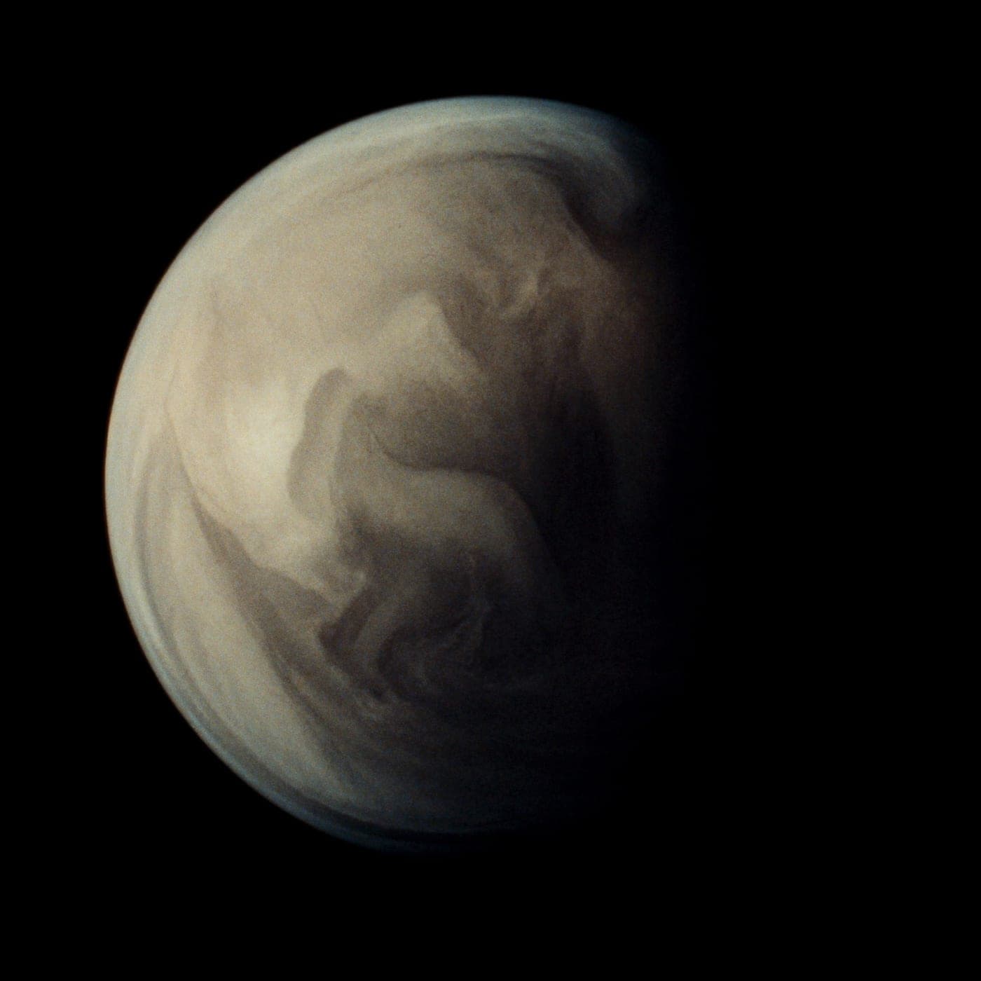 Una sfera di fumo denso che si muove lentamente su fondo scuro.